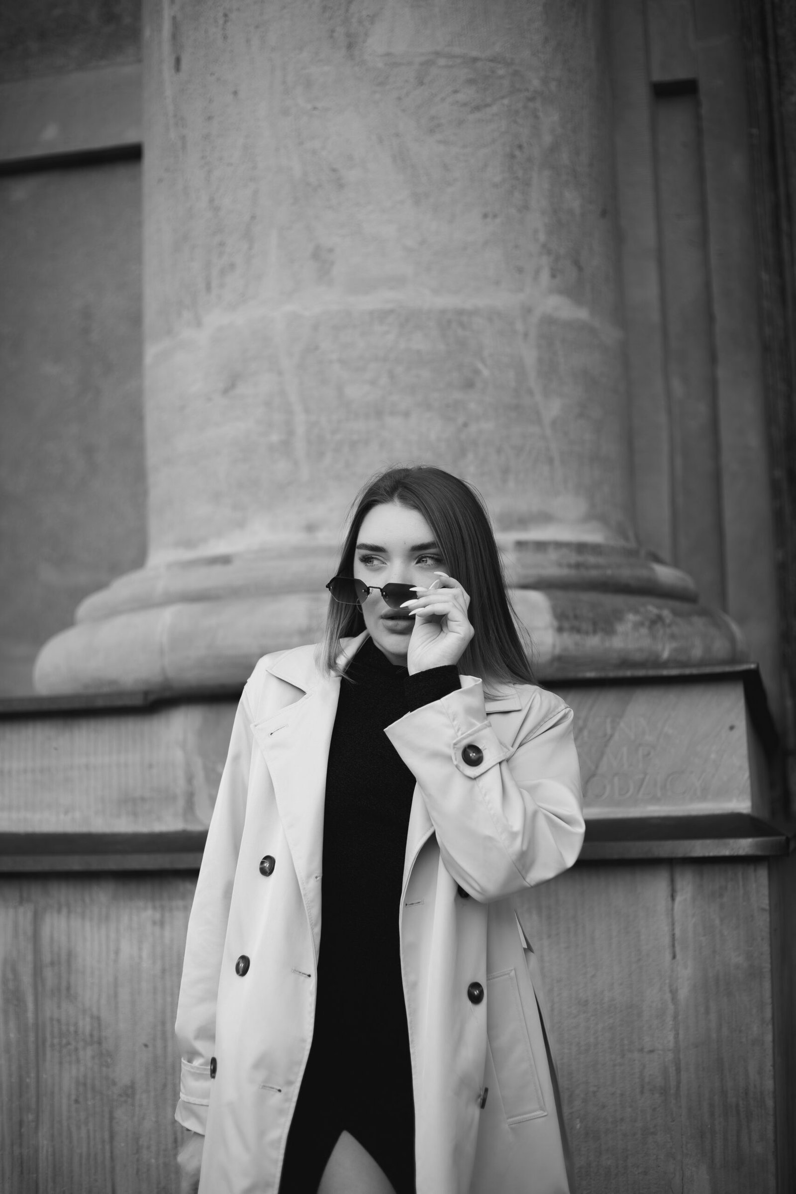 A woman in a trench coat talking on a cell phone